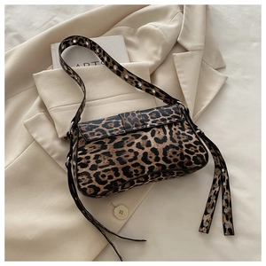 Detail of leopard print handbag with silver eyelets shoulder strap on beige blazer