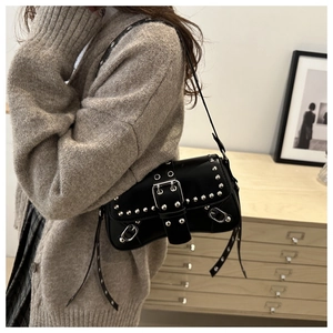 Detail of black punk shoulder bag featuring silver rivets and large metal buckle