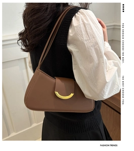 Detail shot of vintage brown shoulder bag with a crescent-shaped gold metal buckle