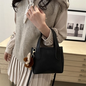 Minimalist black lychee texture leather bucket bag with cute decorative bow pendant
