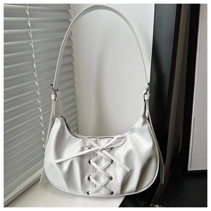 Detailed view of the white half-moon shoulder bag with cross-lacing and silver eyelets