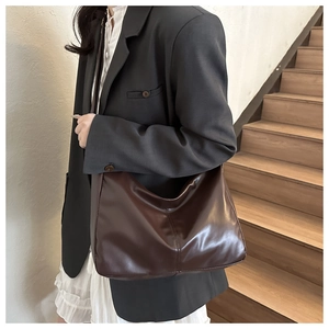 Detail of dark brown leather hobo bag showing glossy texture and large capacity fit