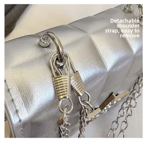 Detail shot of the detachable silver metal chain strap on a metallic tote bag