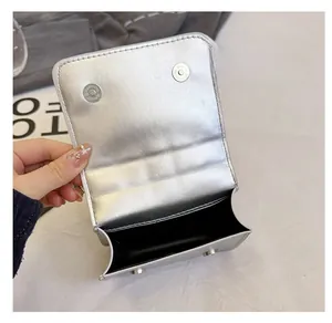 Detailed interior of silver metallic bag showing magnetic closures and inner lining