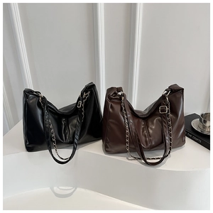 Detail of large vintage PU leather tote bags in black and brown with chain straps
