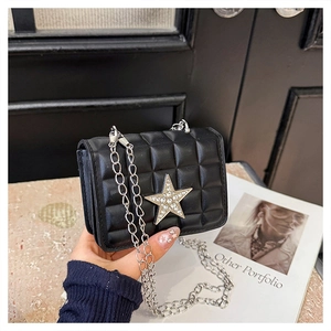 Detail view of black quilted crossbody bag with a sparkling crystal star and chain strap