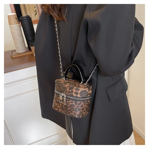 Detail of leopard print mini bucket bag with silver chain strap and double zipper closure
