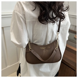 Close-up of brown litchi pattern leather half-moon bag with gold chain strap detail