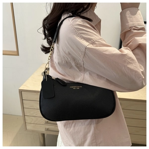 Detail of black pebbled leather crescent bag with gold chain strap and branding