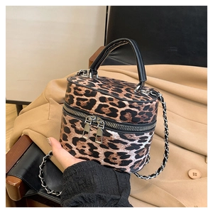 Close-up of leopard print bucket bag with dual silver zippers and chain strap