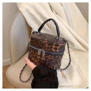 Detailed close-up of leopard print bucket bag featuring dual zippers and chain strap