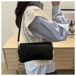 Chic black glossy leather underarm bag with gold metal buckle and irregular flap