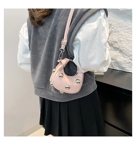 Detailed view of pink hobo bag with silver metal studs and knotted handle detail