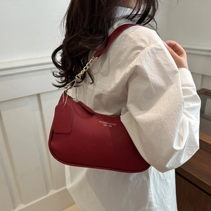 Fashionable red litchi texture underarm bag with gold chain and branding worn by model