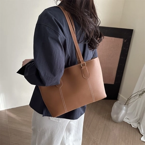 Sac fourre-tout minimaliste en cuir beige avec coutures blanches et longues anses