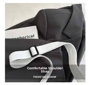Detail of adjustable wide woven shoulder strap on a black minimalist underarm bag