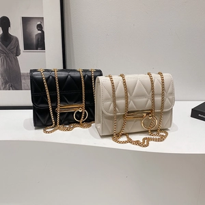 Quilted leather chain bags in black and cream with gold hardware displayed elegantly