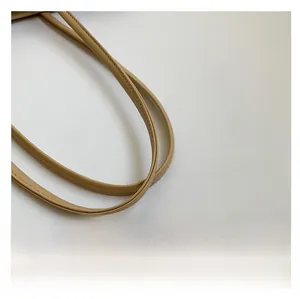 Gros plan de la bandoulière du sac cabas beige avec coutures renforcées