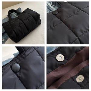 Detail of black quilted tote bag showing square stitching and magnetic closure design