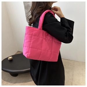 Close-up of bright pink quilted tote bag with soft texture and magnetic button closure