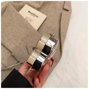 Nahaufnahme der herzförmigen silbernen Spiegel-Clutch mit Kette am Modell