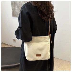 Détail du sac fourre-tout beige en toile avec lanières en cuir brun et vue de dos