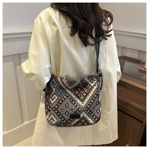 Détail du sac cabas tissé ethnique avec motifs géométriques et bandoulière en cuir
