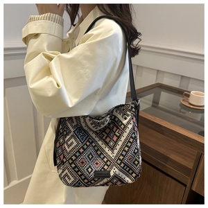 Détail d'un sac cabas en jacquard tissé avec motifs ethniques et bandoulière en cuir