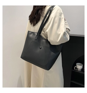 Grand sac cabas noir minimaliste en cuir mat avec poche frontale pratique et bouton métal
