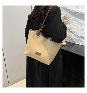 Détail du sac cabas minimaliste avec lanières en cuir et étiquette FASHION