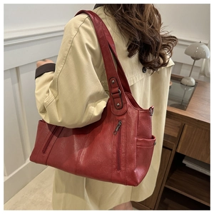 Detail of dark red vintage tote bag with vertical zipper pocket and wide shoulder strap