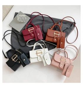 Flat lay of multiple color crossbody bags with gold buckles and matching coin purses