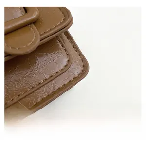 Macro view of dark brown crocodile embossed leather bag with premium stitching details