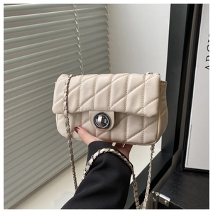 Close-up of cream quilted chain bag with silver twist lock and classic woven strap detail
