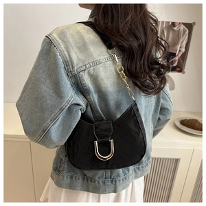 Detail of vintage black hobo bag with pleated texture and metallic D-buckle detail
