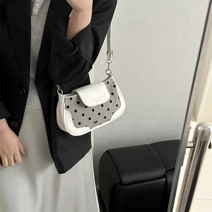 Polka dot canvas and white leather underarm bag for women shown in a lifestyle mirror shot