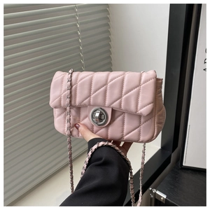 Detail of pink quilted texture with silver metal twist lock and leather chain strap