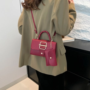 Minimalist burgundy crossbody handbag with matching coin purse and gold buckle detail