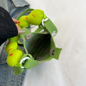 Detalle macro de bolso de punto verde con cierre magnético y el forro del interior