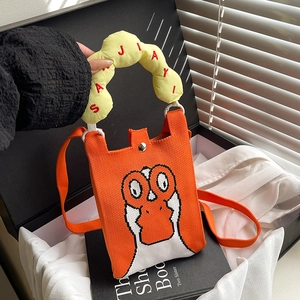 Detalle de mini bolso de punto naranja con diseño de ganso y asa suave amarilla