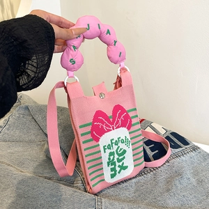 Detalle del mini bolso de punto rosa con lazo grande y asa de textura de burbuja