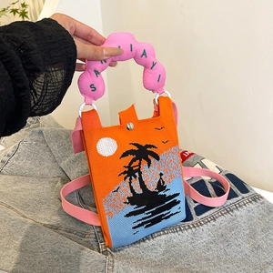 Detalle de mini bolso de punto con diseño de atardecer y asa rosa en forma de nube