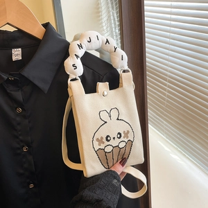 Detalle de bolso de punto con dibujo de conejo y asa suave en forma de nube blanca
