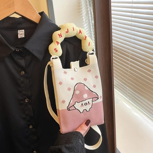 Detalle del bolso de punto para móvil con patrón de setas y asas amarillas acolchadas