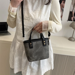 Sac seau en cuir mat gris foncé avec rivets dorés et poignée noire pour femme