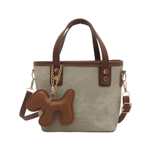 Army green canvas and brown leather crossbody bucket bag with a dog charm decoration