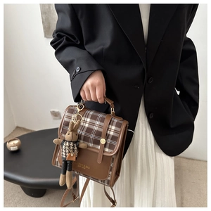 Detail of vintage plaid handbag with leather patchwork and rabbit plush charm