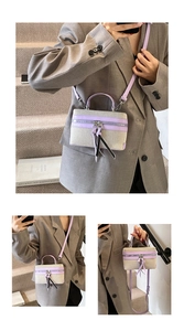 Close-up of beige canvas crossbody bag with purple leather trim and tassel details