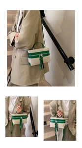 Detail of canvas box bag featuring green leather trim and stylish double zipper pullers