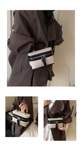 Detail of color-block box bag with canvas texture and stylish long tassel zippers